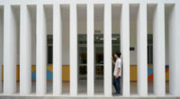 vertical white pillars compose rhythmic facade enfolding primary school in italy